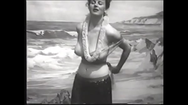 Playful lady with big melons takes off her Hawaiian outfit and shows her round ass on the beach